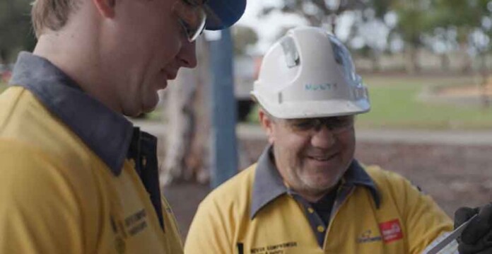 Powercor lineworker apprentice and supervisor wearing safety gear and hardhats