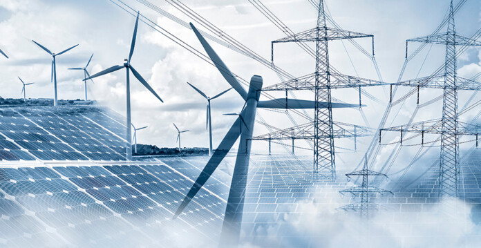 Solar panels and wind turbines pictured with electricity transmission towers in the background (future made in australia)