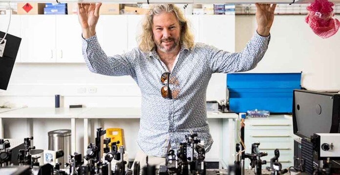 Male researcher in lab with microscopes and equipment