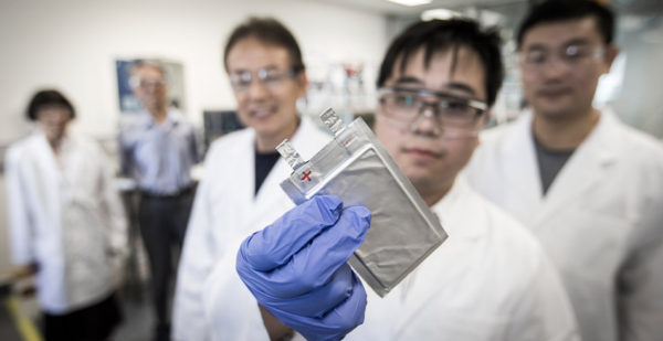 A lab researcher holding a full-cell sodium-ion battery pouch (sparc)