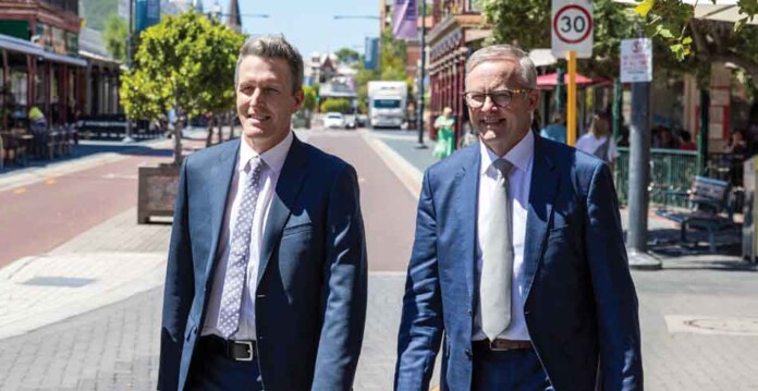 Fremantle MP Josh Wilson walks side by side down street with Australian Prime Minister Anthony Albanese